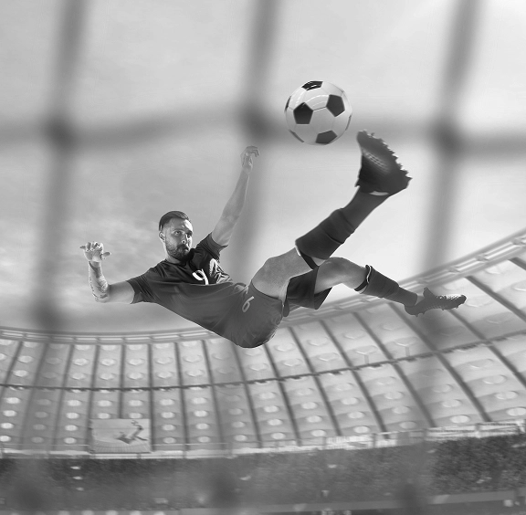 Piłkarz wykonujący efektowną przewrotkę na stadionie podczas akcji meczowej